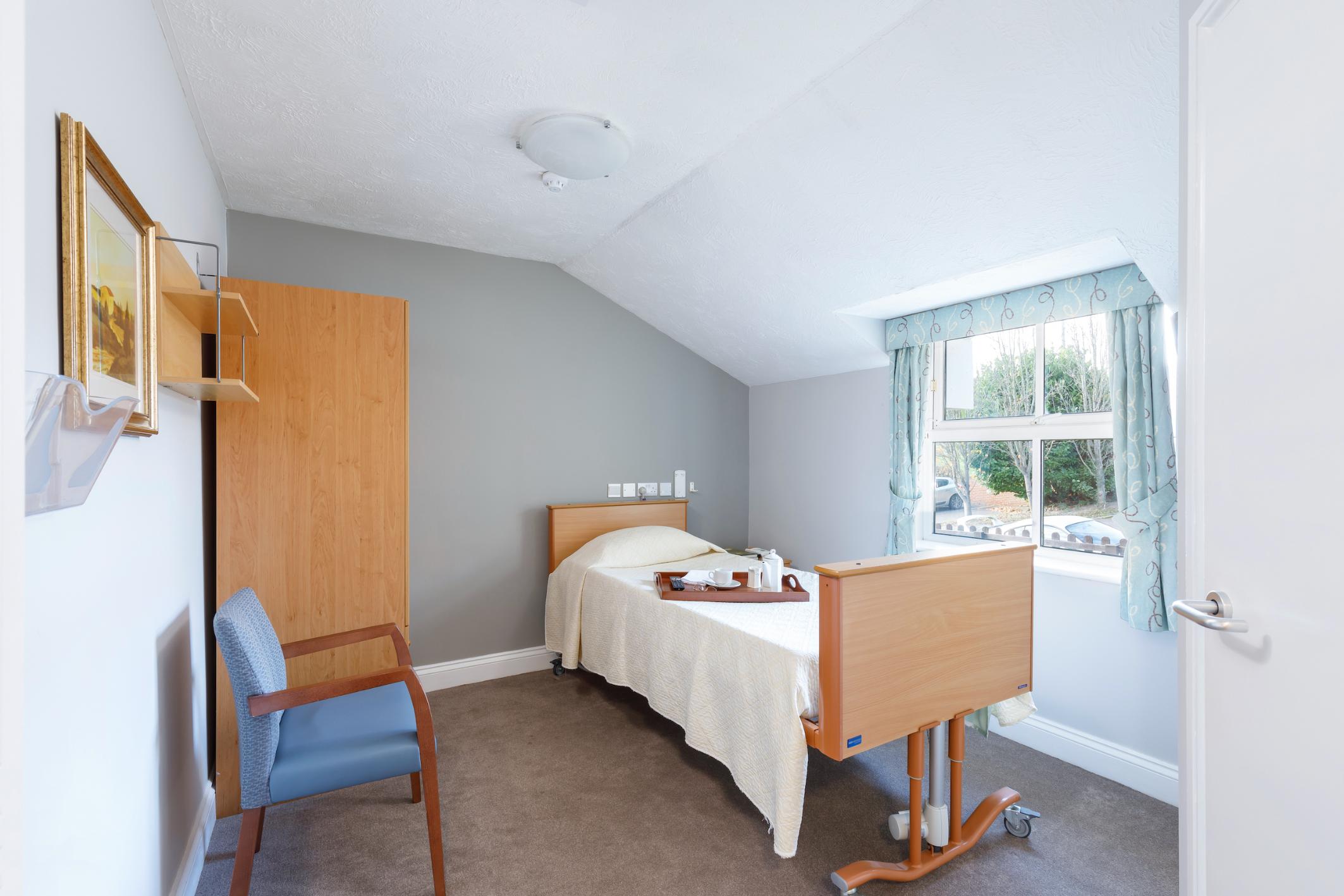 care home bedroom with single bed and window